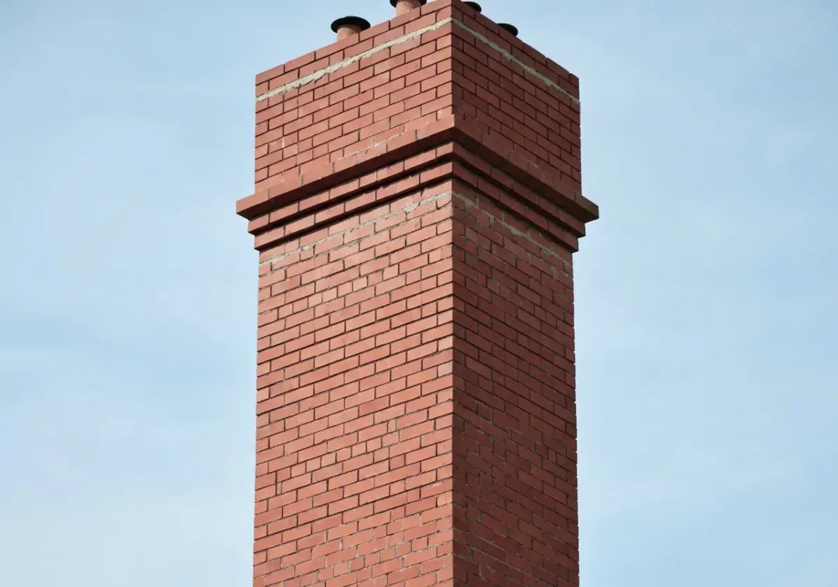 After — chimney repair: Flaking brick and washed-out joints rebuilt into a tight, weather-shedding stack.
