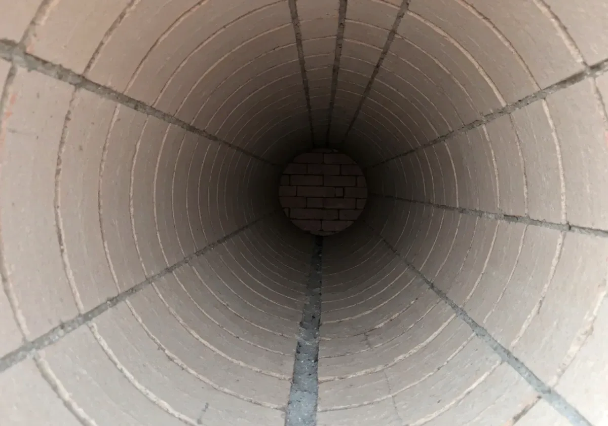 After — creosote removal: Glazed third-stage creosote ground off the flue walls — the fuel for a chimney fire, gone.